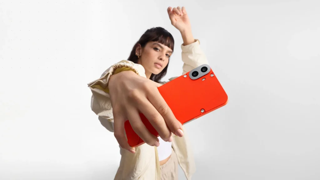 Nothing CMF Phone 1, in Orange, held out towards the camera