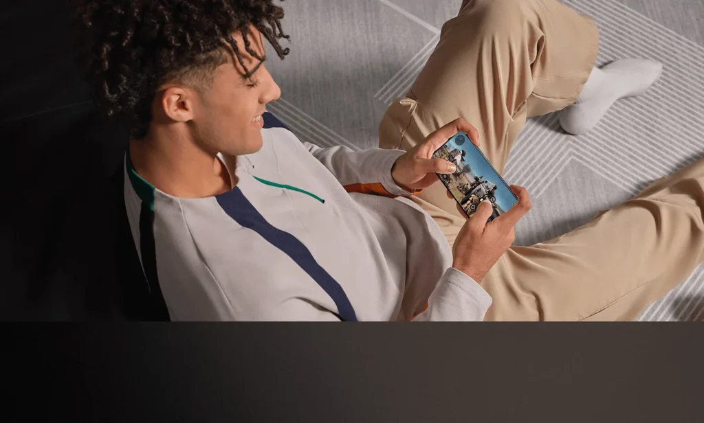 Poco X7, used for gaming on a sofa
