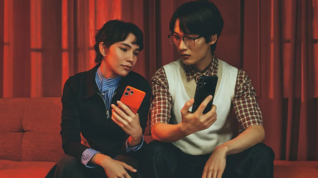 Nothing CMF Phone 2 Pro, in Orange and Black, held by two people