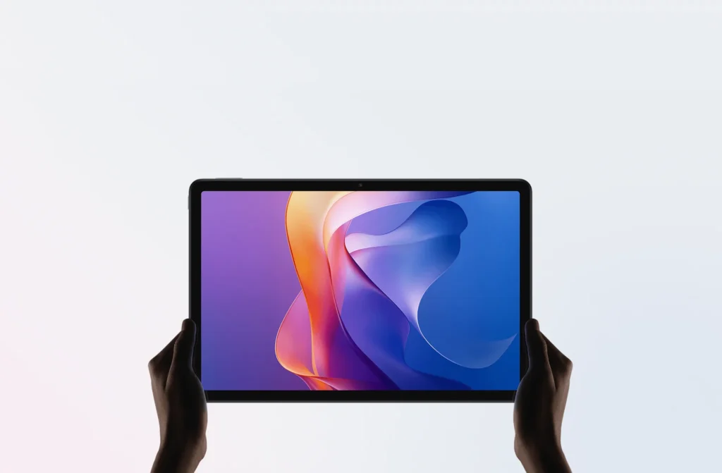 Xiaomi Redmi Pad 2, held in two hands from the front, purple and blue wallpaper on screen