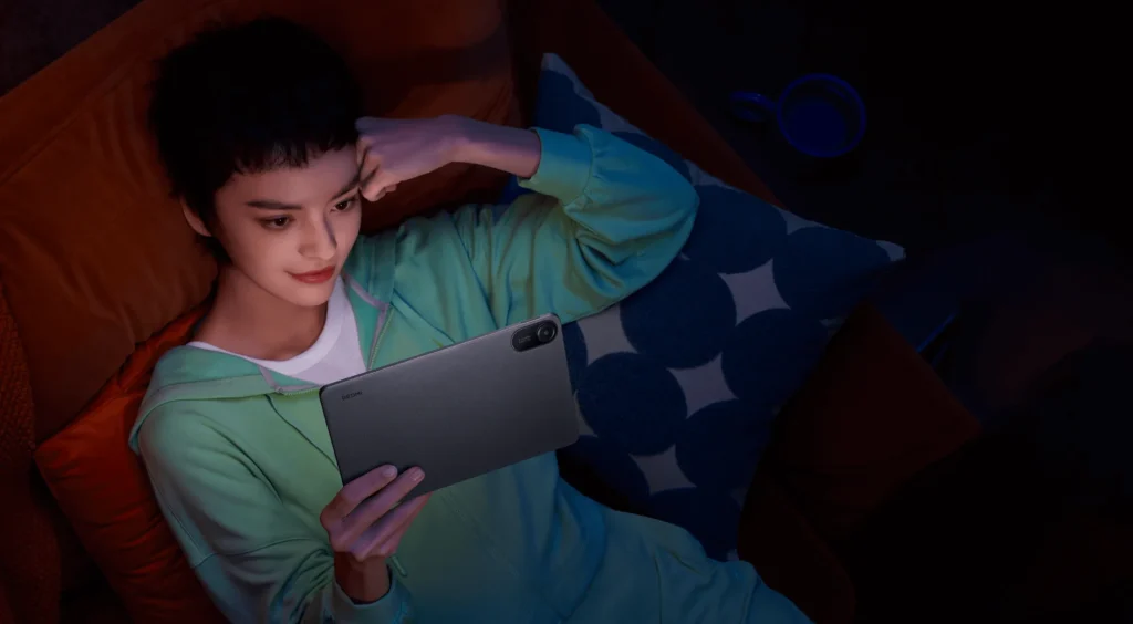Xiaomi Redmi Pad 2, someone lying back reading it in a dark room