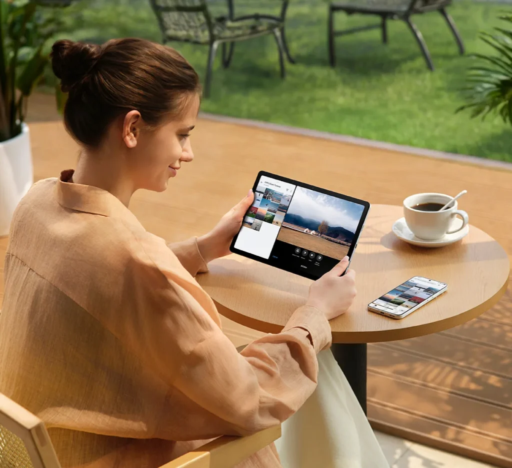 OPPO Pad SE, held at an outdoor cafe table next to a phone