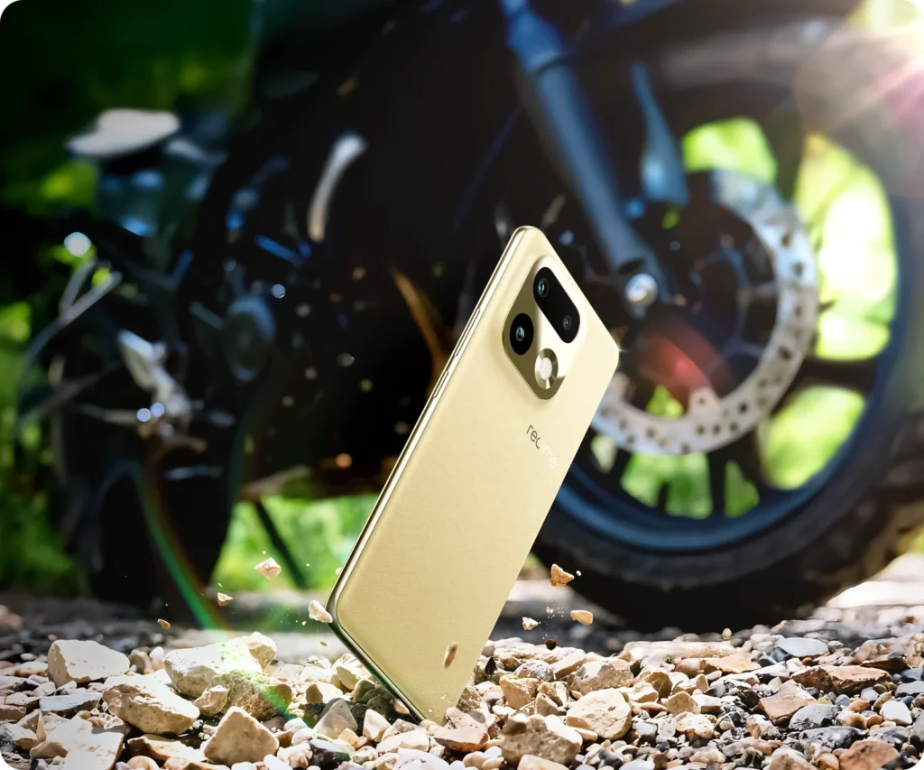 realme 16 Pro+ 5G, in Master Gold, against a motorbike wheel