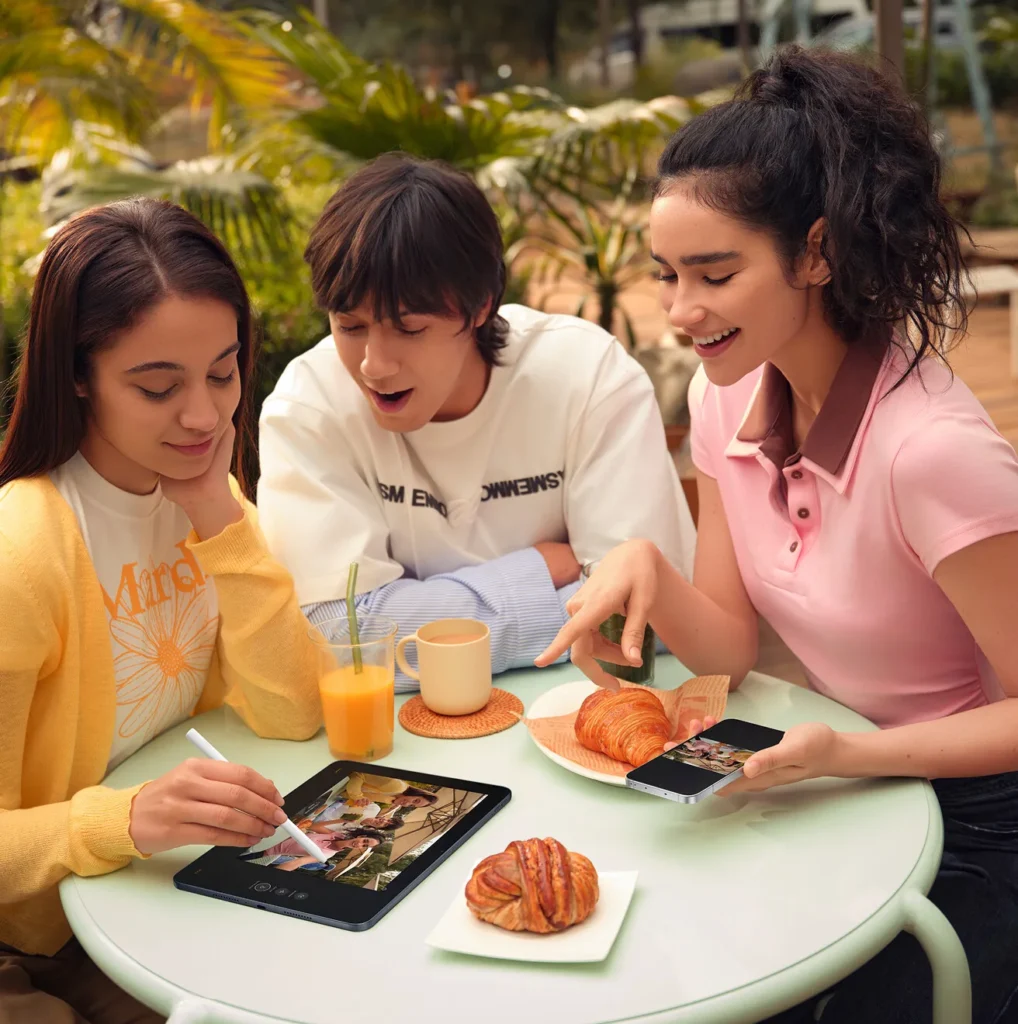 OPPO Pad 5, three friends drawing on it at a cafe table