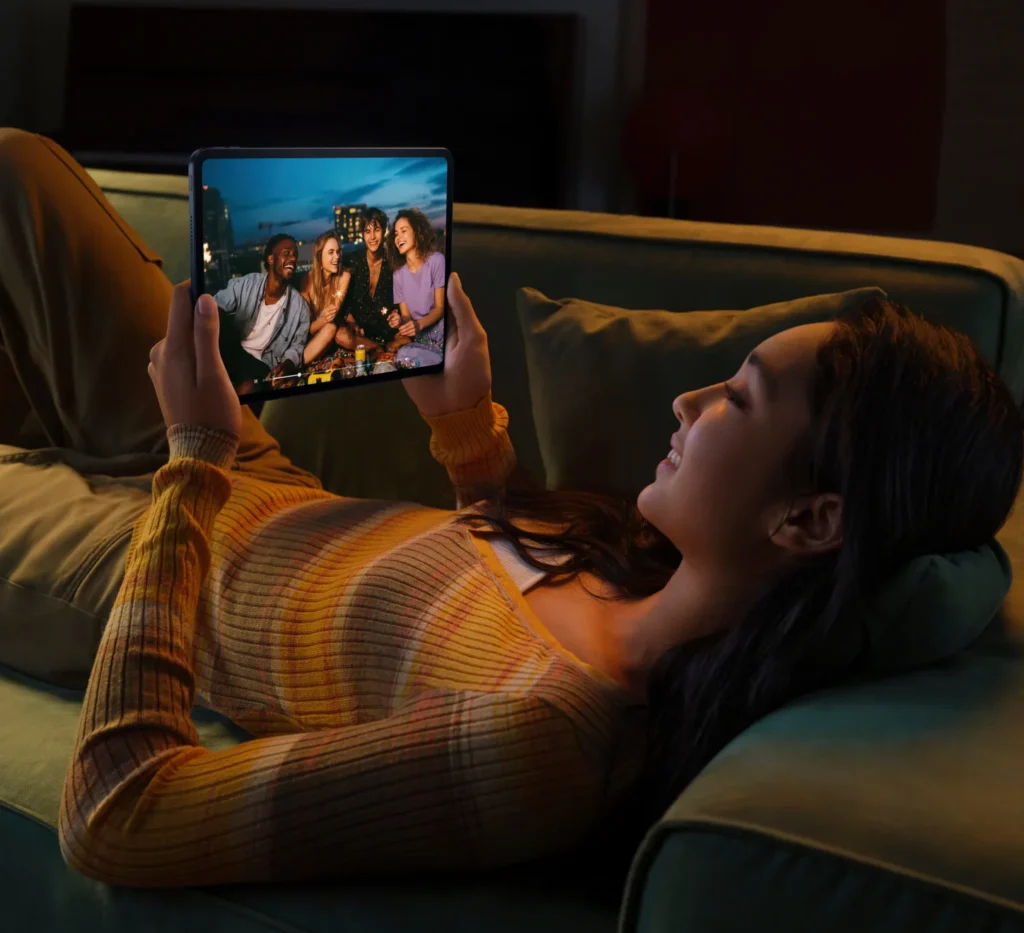 OPPO Pad 5, held up by a woman lying on a sofa