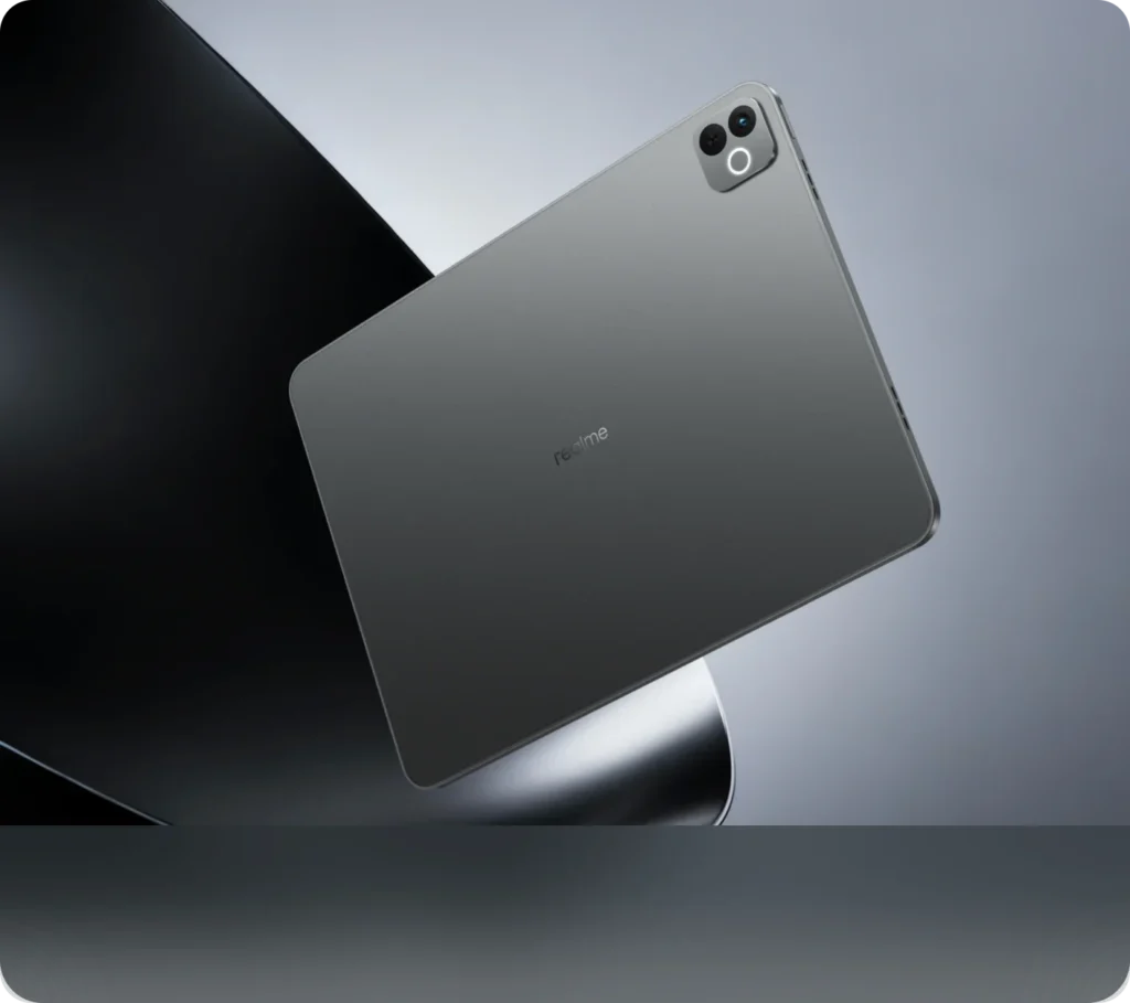 realme Pad 3, in Space Grey, from the back, against a grey and black backdrop