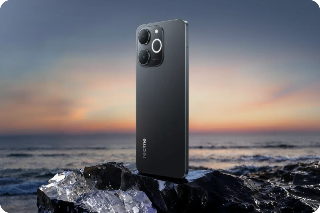 realme P4 Lite, in Obsidian Black, on rocks at sunset