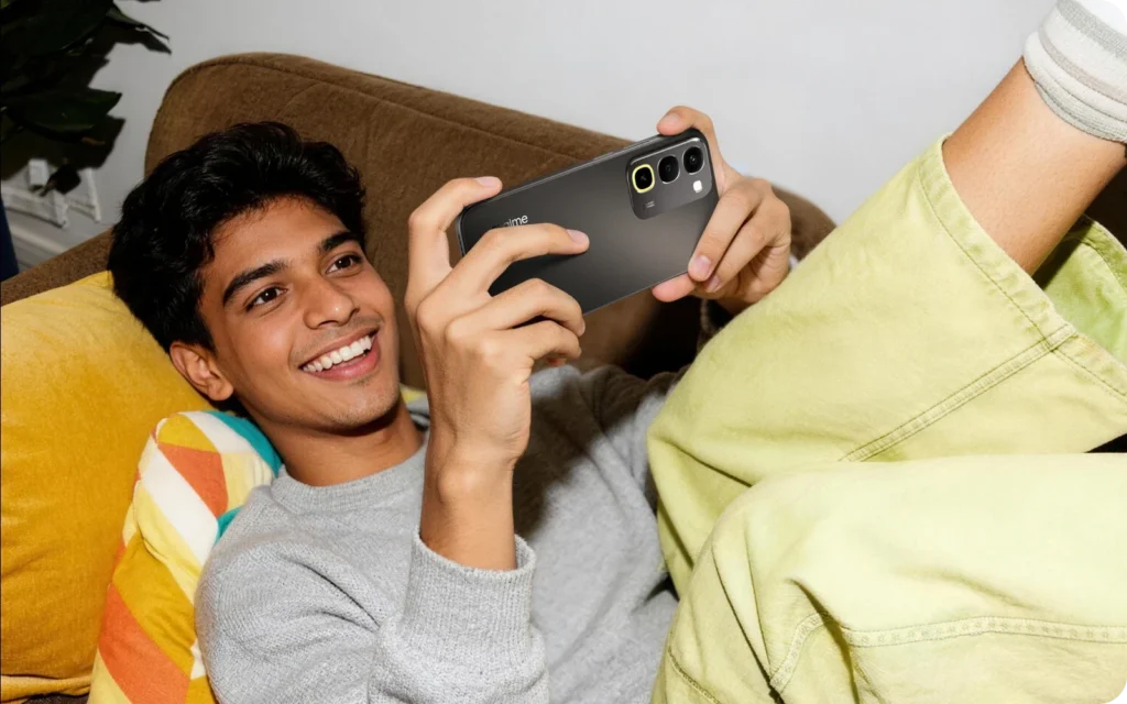 realme P4R 5G, held by a man on a sofa