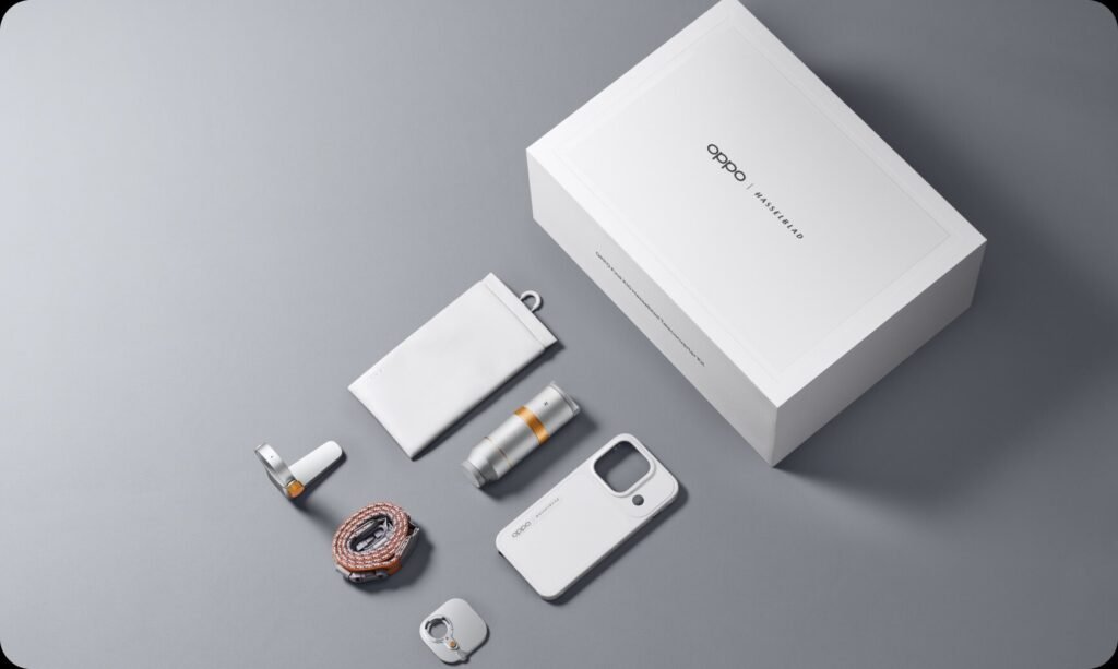 OPPO Hasselblad Teleconverter Kit laid out on a grey surface with its white box, zoom lens, phone case, strap and pouch