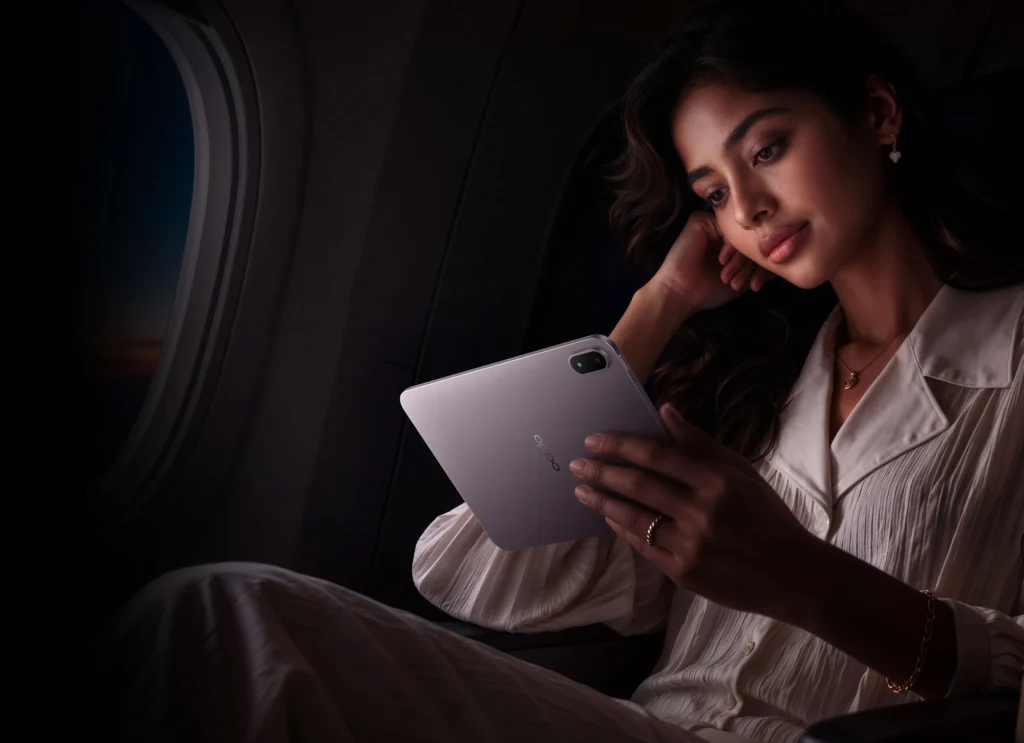 OPPO Pad Mini, held by a woman in a dim plane cabin