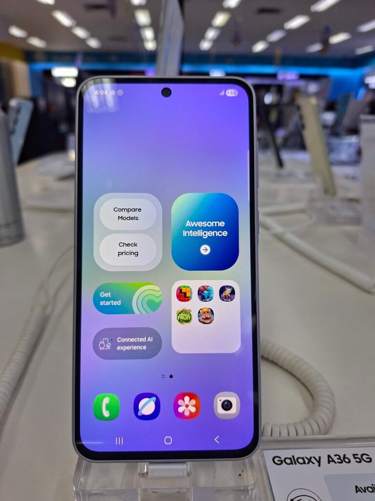 A Samsung Galaxy A36 5G on a shop display stand showing a comparison screen